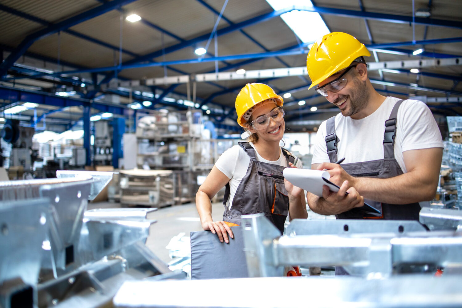 Twee medewerkers overleggen samen in een productiehal